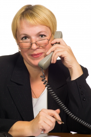 Mature businesswoman calling on the phone at her workplace  Isolated against white background の写真素材
