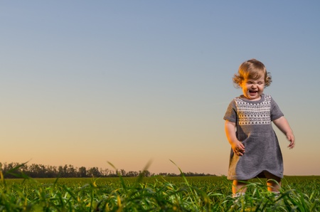 Little girl playing on the field の写真素材