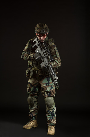 NATO soldier in full gear. Military man over black background.の写真素材