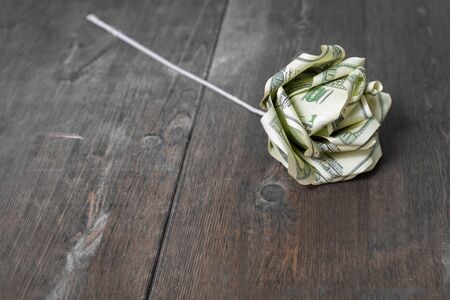 Flower of dollar banknotes on the wooden surfaceの写真素材