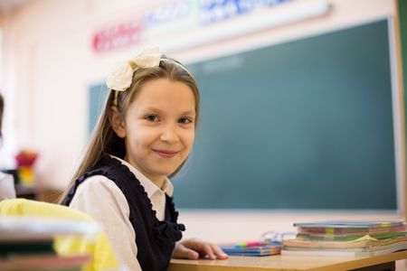 Schoolgirl at classroom against blackboard.の写真素材