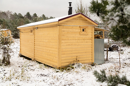 Closeup shoot of new wooden cabin ap the winter field and forestの写真素材