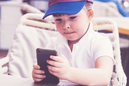Little girl playing with smartphoneの写真素材