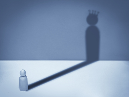 Man with crown shadow. Business symbol of ambition, success, motivation, leadership and challenge.
