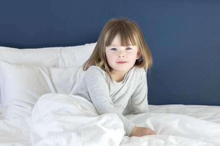 Girl stretching on the bedの写真素材