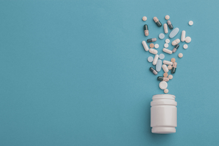 pills an pill bottle on green backgroundの写真素材