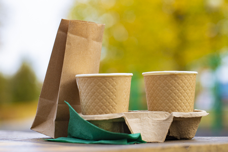 Cups of coffee to go at wooden backgroundの写真素材