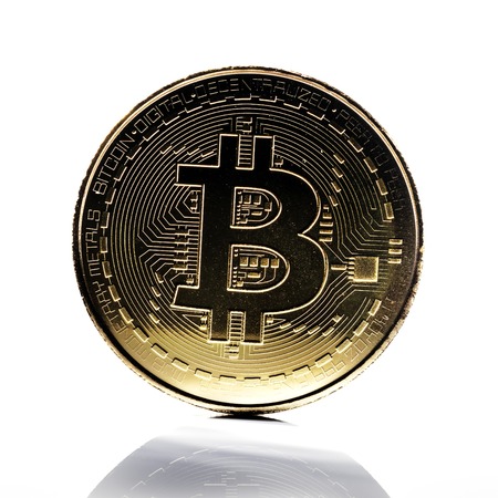 Bitcoin. Physical bit coin. Digital currency. Cryptocurrency. Golden coin with bitcoin symbol on white background with reflectionの写真素材