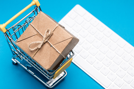 Online shopping and delivery service concept. Paper box in a shopping cart on a keyboardの写真素材