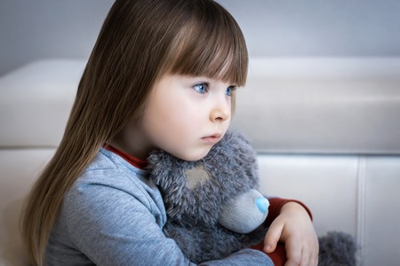Portrait of little girl, Kid sad face sitting alone in the room,の写真素材