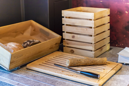 Pieces of french baguette bread and knife on a wooden chopping board