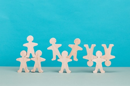 Several wooden figures in different situations. Teamwork concept. Brainstorm. New ideas. Non-standard approach to solving problems.の写真素材