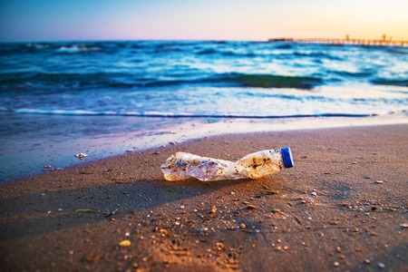 Plastic bottle is on the beach leave by touristの写真素材