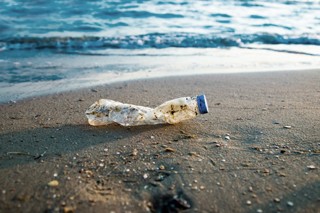 Plastic bottle is on the beach leave by touristの写真素材