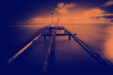 Sunrise over the sea. Pier on the foregroundの写真素材