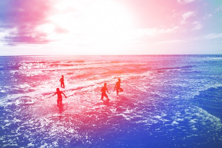 Silhouettes of boys running to the sea. Tonedの写真素材