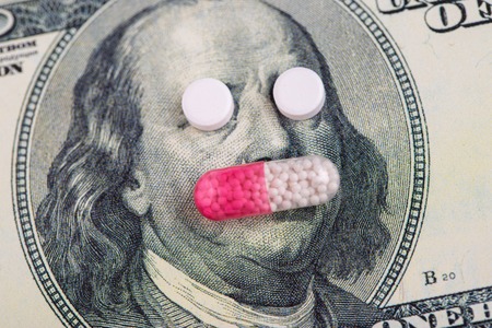 A pills lie in place of the eyes, on a bill of one hundred dollars close-up. The concept of insurance medecine, high cost, high cost of drugs. Costly treatment.の写真素材
