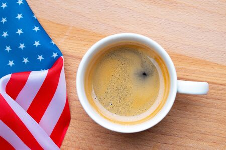 Independence Day USA concept. Memorial Day. Cup of coffee with American flag on white background top viewの写真素材