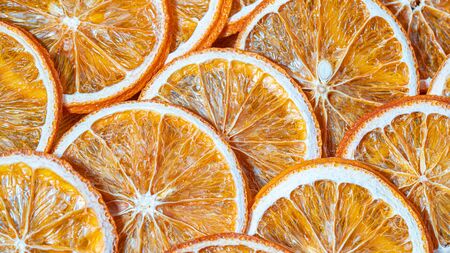 Dried orange slices chips background. Dehydrated crispy fruit slices.の写真素材