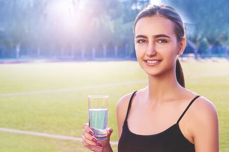 Portrait of young woman drinking water, outdoor, copyspaceの写真素材
