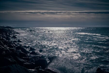 Dramatic sea and strip of the coast with the sun sunsetの写真素材