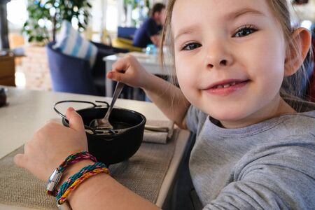 little girl eating dumpling in cafe