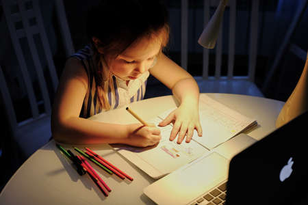 Astrakhan/Russia - May 28, 2020: Online lesson of a little girl at home. Hight quality photoのeditorial素材