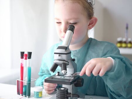 A little girl does scientific work in her home laboratory. The concept is the children of the future. High quality photoの写真素材