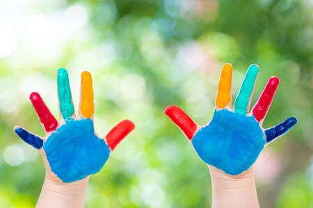Child hands painted in colorful paints ready for hand prints.の写真素材
