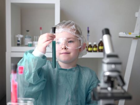 A little girl does scientific work in her home laboratory. The concept is the children of the future. High quality photoの写真素材
