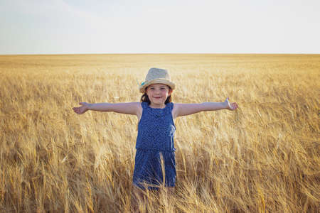 An emotional portrait of a little girl in a wheat field. High quality photoの写真素材