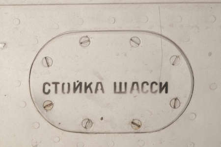 Old silver metal surface of the aircraft fuselage with rivets. The inscription in Russian "landing gear"の写真素材