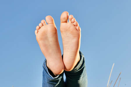 Baby barefoot burdens against the blue sky. High quality photo
