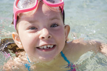 Portrait of a funny little girl in swimming glasses at sea. High quality photoの写真素材
