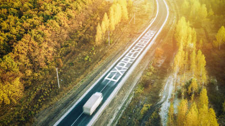 Truck traveling on road at sunrise - speed and delivery concept. Motion blur. Aerial