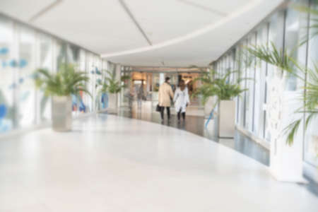 Abstract blur shopping mall corridor. Blurred retail and hall interior in department store. Defocused bokeh effect background or backdrop for business concept. High quality photoの写真素材