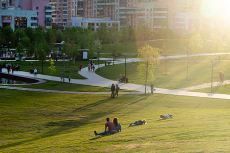 Russia, Moscow - 15 May 2021: Khodynka field, Park and residential area. People relax in the city Park at sunset on a hot day. High quality photoのeditorial素材