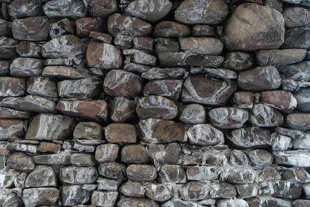 Texture of a stone wall. Old castle stone wall texture background. Stone wall as a background or texture. Part of a stone wall, for background or texture. High quality photoの写真素材
