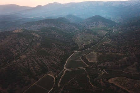 A long and winding road passing through green hills. High quality photoの写真素材