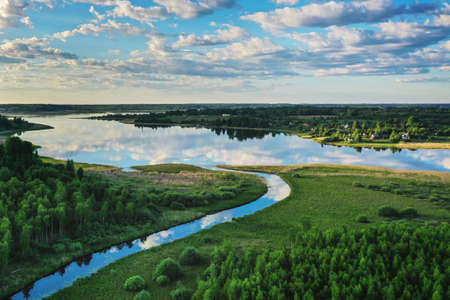 Sunny summer landscape with river bend, fields, green hills and beautiful clouds in blue sky. High quality photoの写真素材