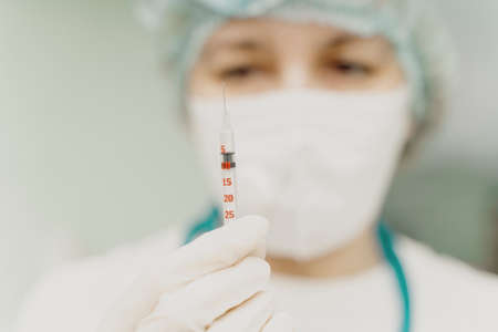 The doctor holds a syringe with an injection in his hands. Selected Focus. High quality photoの写真素材