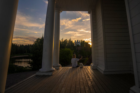 A girl takes a selfie using a smartphone in MonRepo Park during the White Nights near the city of Vyborg, Russia. High quality photoの写真素材