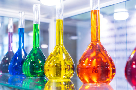 A closeup shot of bottles filled with colorful liquids on the shelves. High quality photoの写真素材