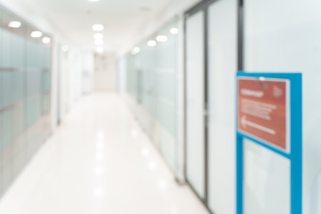 Blurred empty open space corridor. Abstract light bokeh at office interior background for design. High quality photoの写真素材