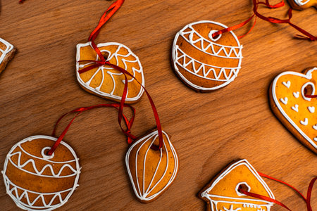 Wooden background with lots of gingerbread Christmas gingerbread in the shape of a house, heart. Deer. star, christmas tree toy, ball with white glaze. High quality photoの写真素材