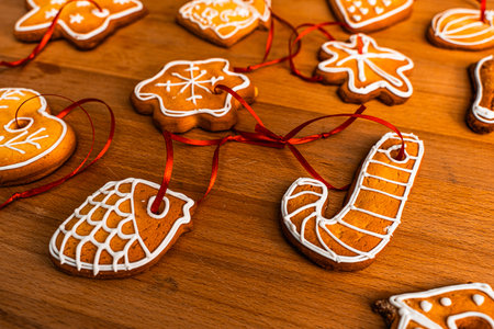 Wooden background with lots of gingerbread Christmas gingerbread in the shape of a house, heart. Deer. star, christmas tree toy, ball with white glaze. High quality photoの写真素材