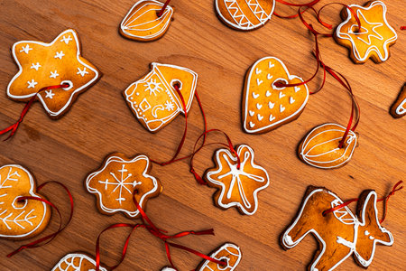 Wooden background with lots of gingerbread Christmas gingerbread in the shape of a house, heart. Deer. star, christmas tree toy, ball with white glaze. High quality photoの写真素材