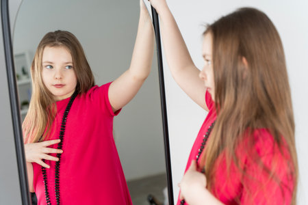 Young girl looking at herself in the mirror. High quality photoの写真素材