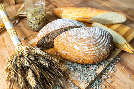 Wheat bread with lichen and ears of wheat on a wooden board. Healthy food concept. High quality photoの写真素材
