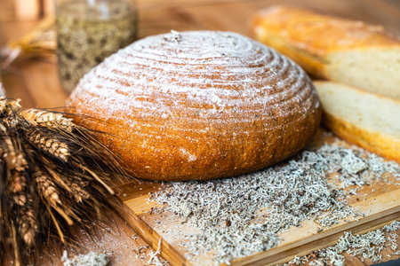 Freshly baked bread with dietary supplements on the table. Still life of bread, baguette, ears of corn, deer moss. High quality photoの写真素材